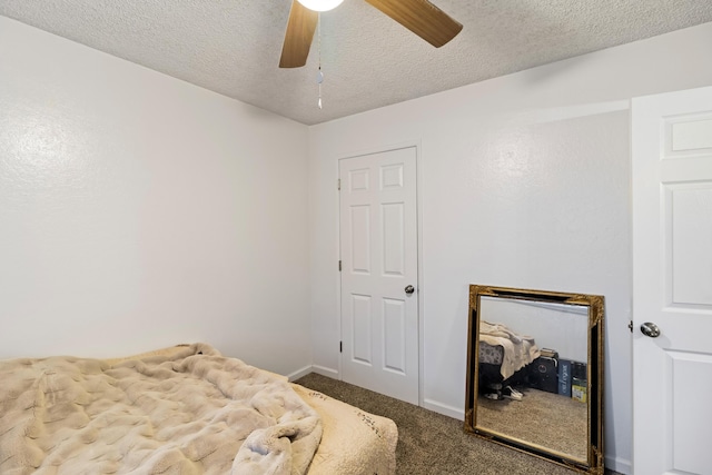 bedroom with ceiling fan, carpet floors, and a textured ceiling