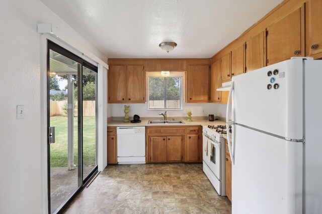2548 Saturn, Redding, CA 96002 - kitchen featuring white appliances, a sink, under cabinet range hood, light countertops, and brown cabinets