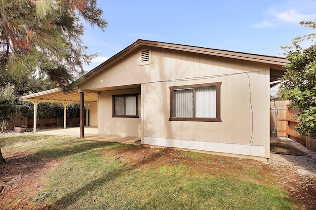 view of side of home with a yard and a patio