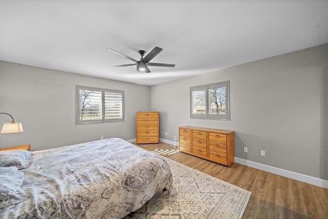 bedroom featuring ceiling fan, baseboards, and wood finished floors