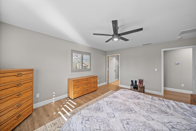 bedroom featuring light wood-style floors, visible vents, baseboards, and a ceiling fan