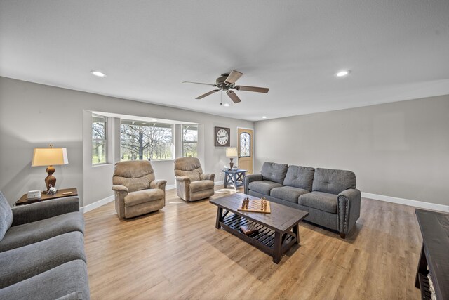 living area featuring ceiling fan, light wood finished floors, recessed lighting, and baseboards