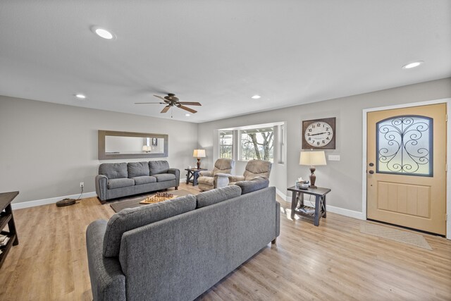 living room featuring baseboards, light wood finished floors, and recessed lighting