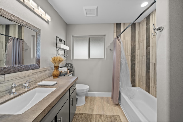 full bath with toilet, shower / bath combo, vanity, wood finished floors, and baseboards