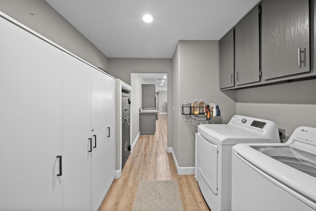 washroom with cabinet space, light wood-style flooring, baseboards, and separate washer and dryer