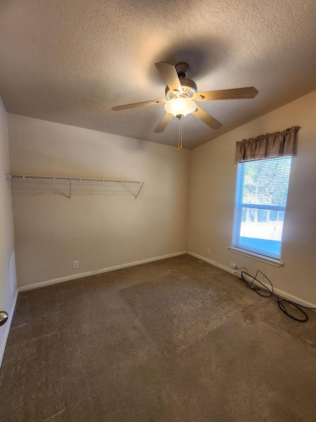 carpeted spare room with ceiling fan, vaulted ceiling, and a textured ceiling