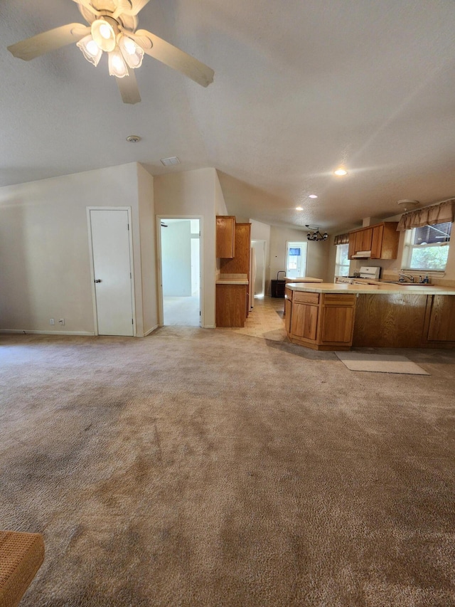 kitchen with light colored carpet, ceiling fan, and kitchen peninsula