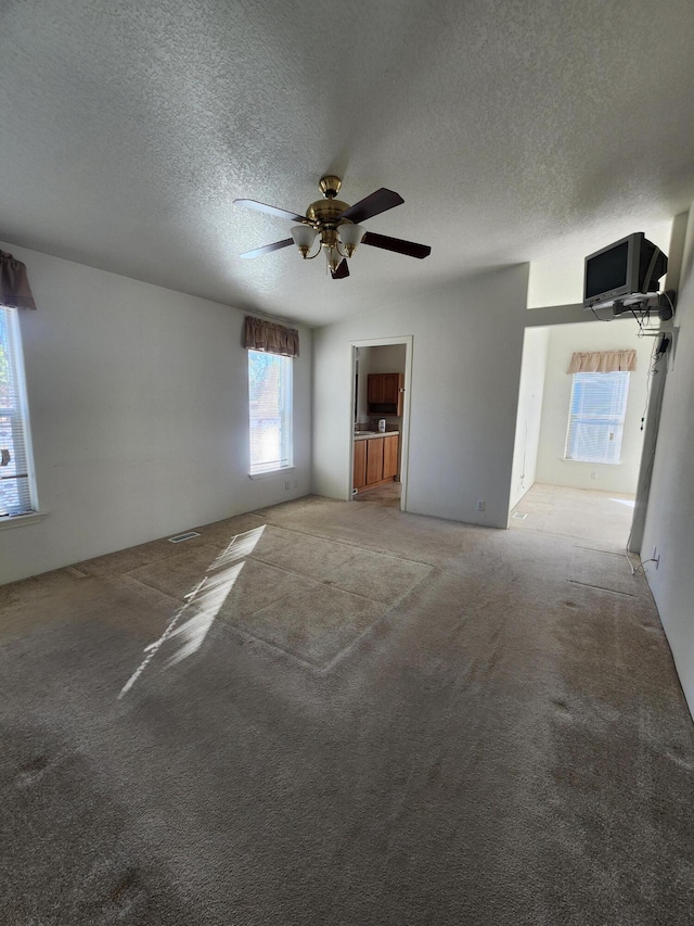 unfurnished room with light carpet, a textured ceiling, and ceiling fan