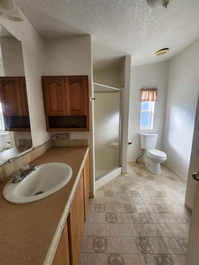 bathroom featuring vanity, an enclosed shower, a textured ceiling, and toilet