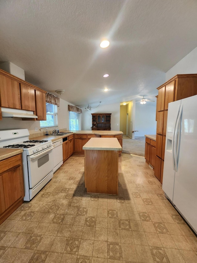 kitchen with white appliances, a textured ceiling, a center island, and ceiling fan