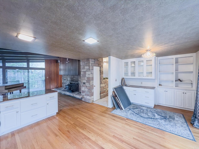 kitchen with white cabinetry, light hardwood / wood-style flooring, and a textured ceiling