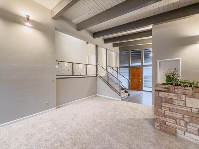 carpeted empty room with beamed ceiling and wood ceiling