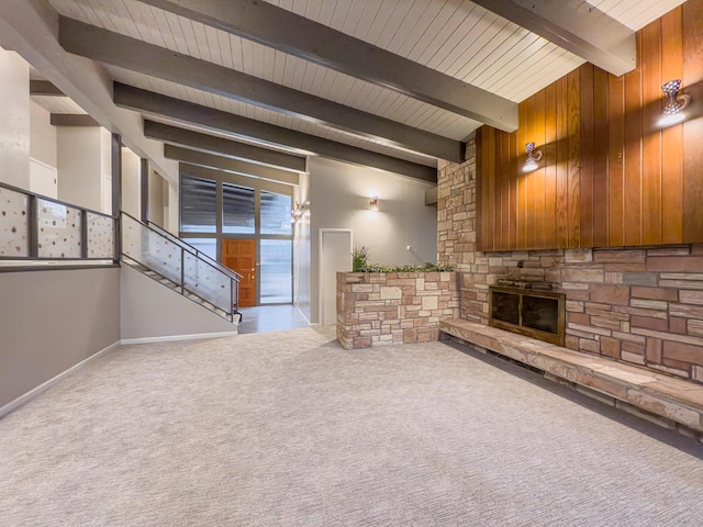 unfurnished living room with beam ceiling, carpet flooring, and a fireplace