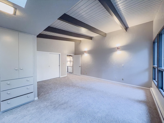 empty room featuring a baseboard radiator, carpet flooring, and beam ceiling