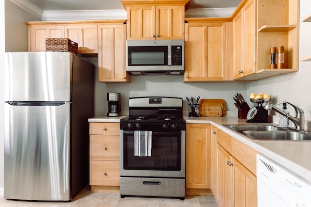 kitchen featuring stainless steel appliances, light countertops, a sink, and light brown cabinetry