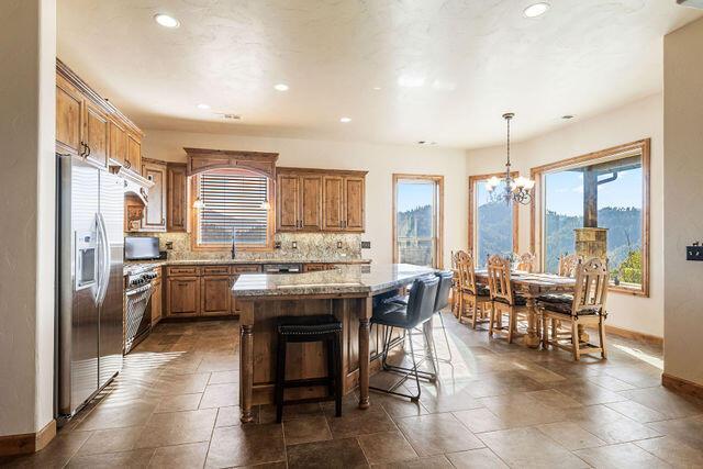 kitchen featuring a breakfast bar area, decorative light fixtures, appliances with stainless steel finishes, a kitchen island, and decorative backsplash