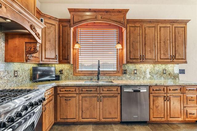 kitchen featuring tasteful backsplash, sink, light stone countertops, and appliances with stainless steel finishes