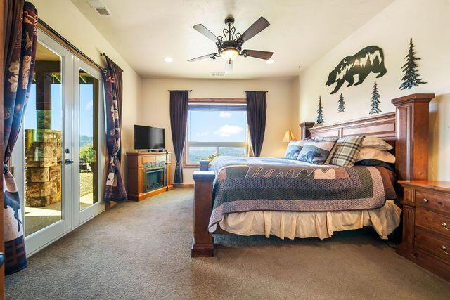 carpeted bedroom with access to exterior, french doors, and ceiling fan