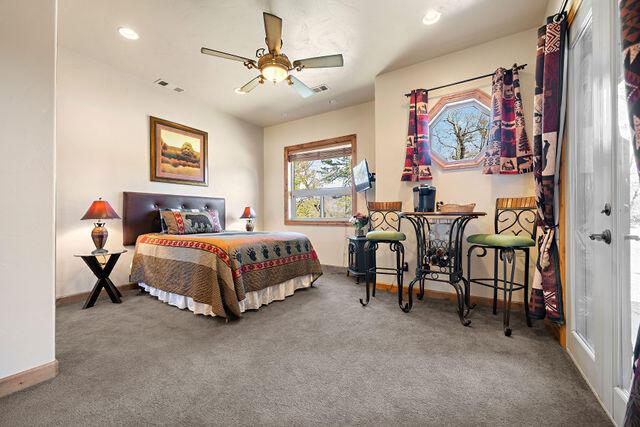 bedroom featuring ceiling fan and carpet