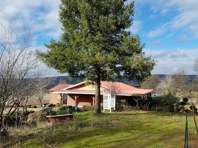 view of side of property featuring a yard and metal roof