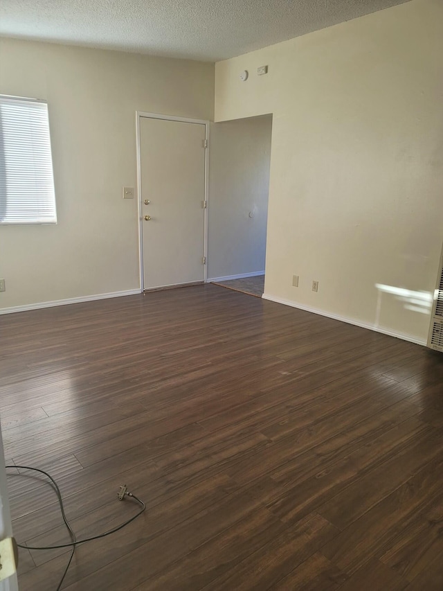 empty room featuring dark hardwood / wood-style flooring and a textured ceiling