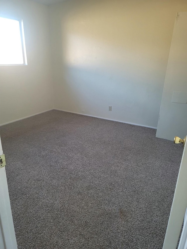 unfurnished room featuring dark colored carpet