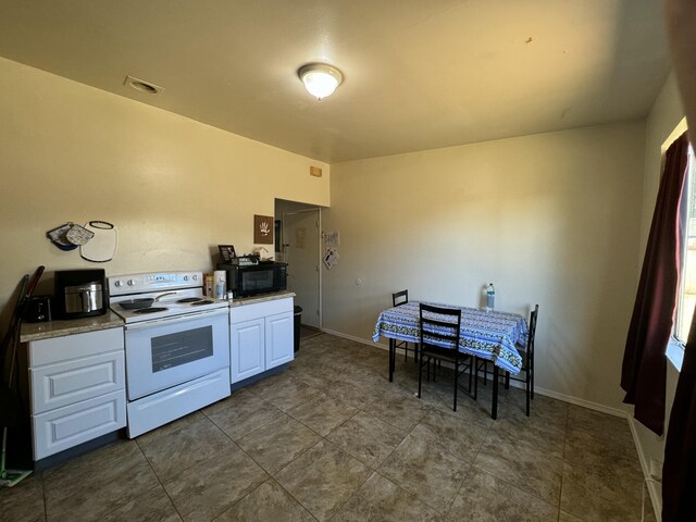 kitchen featuring white cabinetry and white electric range oven