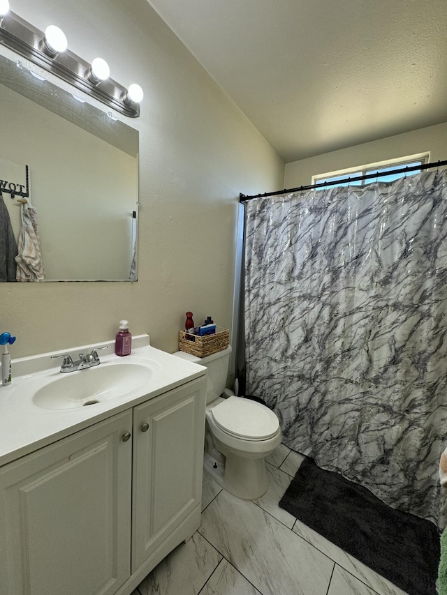 bathroom with a shower with curtain, vanity, lofted ceiling, and toilet