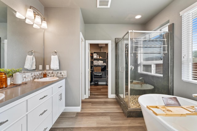 bathroom with hardwood / wood-style flooring, vanity, and independent shower and bath