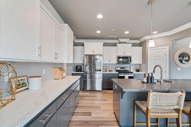 kitchen with stainless steel appliances, white cabinetry, hanging light fixtures, and gray cabinetry