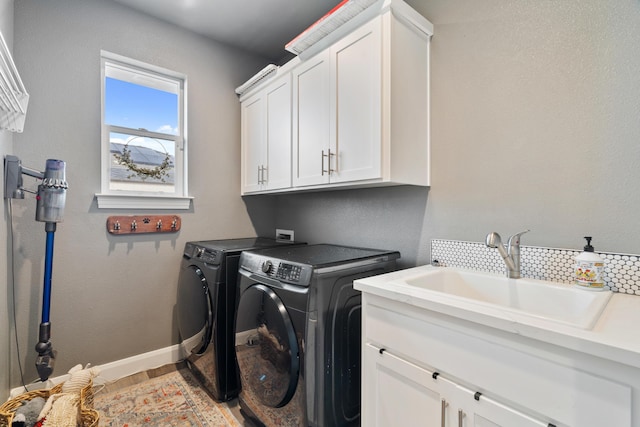 laundry area featuring cabinets, independent washer and dryer, and sink