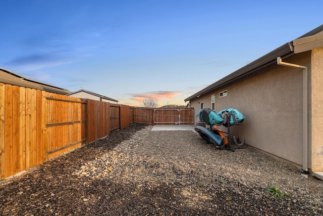 yard at dusk featuring a patio