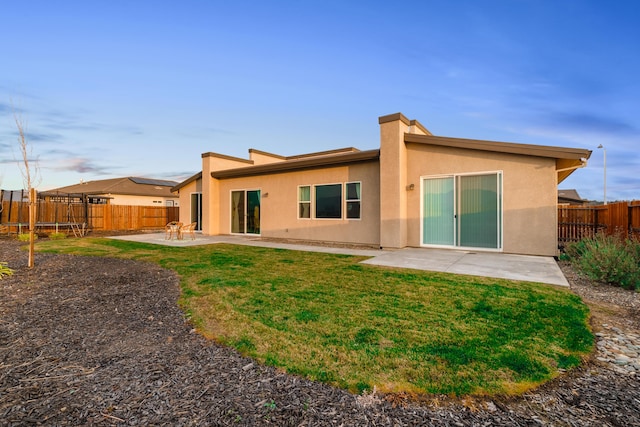 back of house featuring a yard and a patio