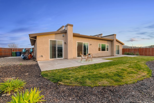 rear view of property featuring a yard and a patio