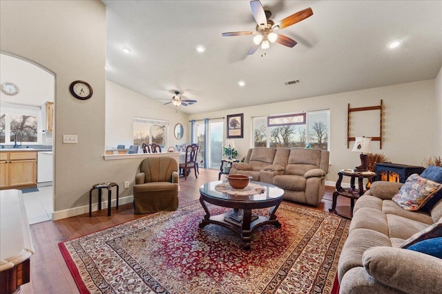 living room featuring hardwood / wood-style flooring, vaulted ceiling, sink, and ceiling fan