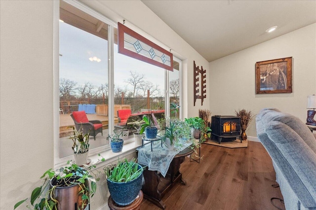 interior space with lofted ceiling, wood-type flooring, and a wood stove