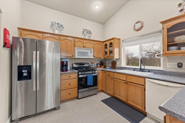 kitchen with sink, light tile patterned floors, high vaulted ceiling, and appliances with stainless steel finishes