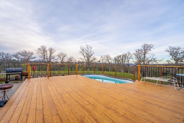 wooden deck with a fenced in pool and grilling area