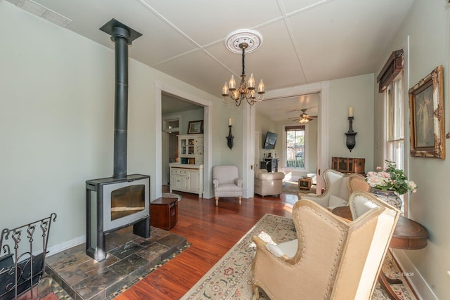 living room featuring dark hardwood / wood-style floors, ceiling fan, and a wood stove