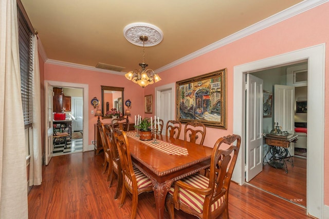 dining space featuring dark hardwood / wood-style flooring, a notable chandelier, and ornamental molding