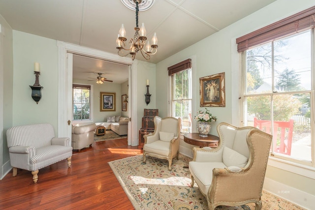 living area with dark hardwood / wood-style floors and an inviting chandelier