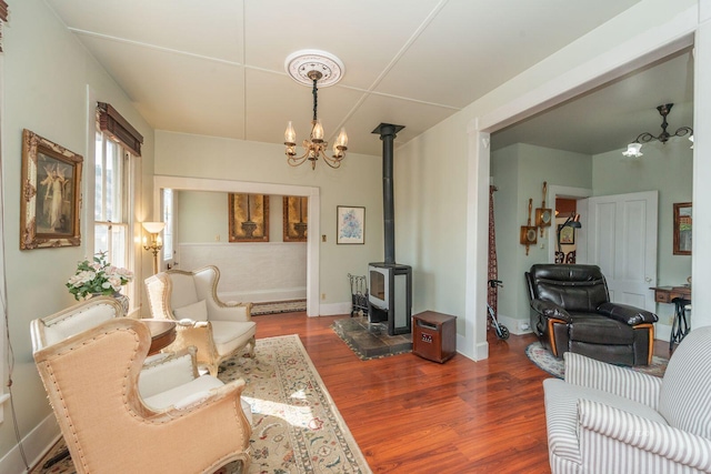 living room featuring a wood stove, hardwood / wood-style floors, and a chandelier