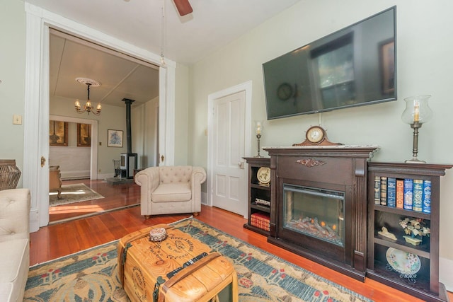 living room featuring hardwood / wood-style floors, ceiling fan, and a wood stove