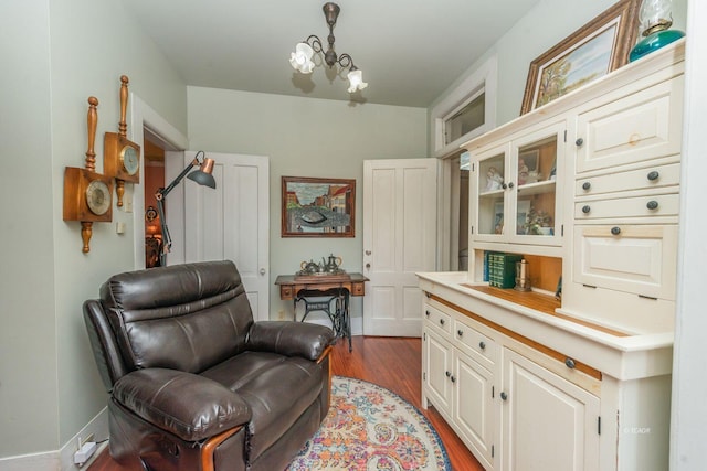 sitting room with an inviting chandelier and hardwood / wood-style flooring