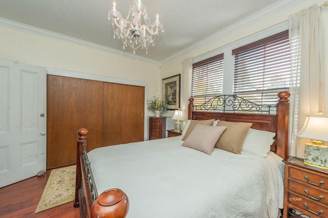 bedroom featuring crown molding, dark hardwood / wood-style floors, an inviting chandelier, and a closet