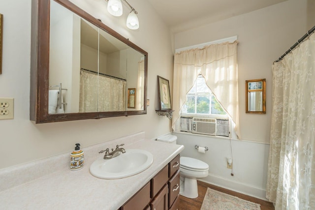 bathroom featuring hardwood / wood-style flooring, vanity, cooling unit, and toilet