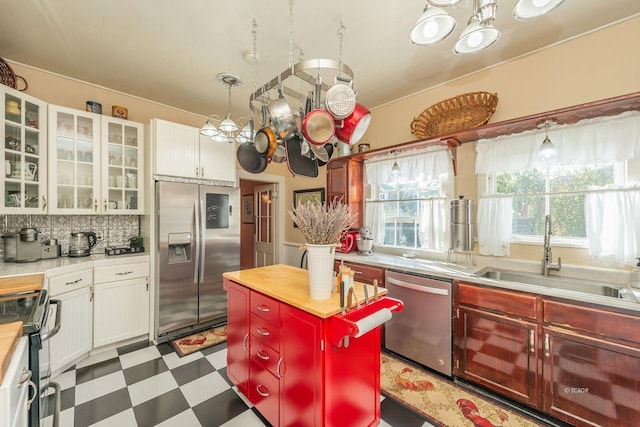 kitchen featuring a kitchen island, white cabinetry, appliances with stainless steel finishes, and sink