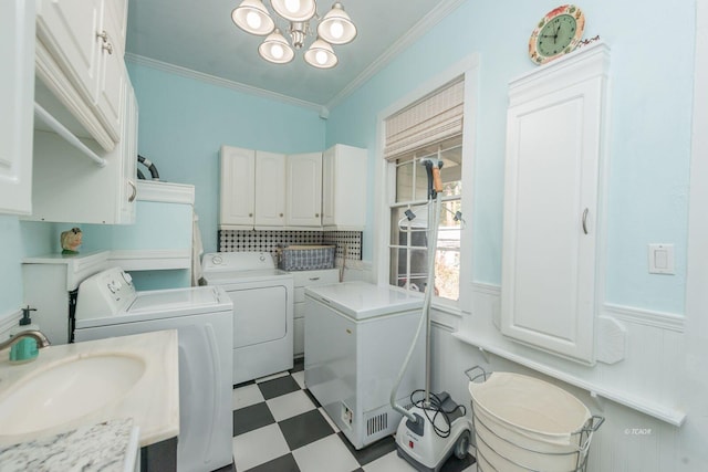 laundry area featuring ornamental molding, separate washer and dryer, sink, and a notable chandelier