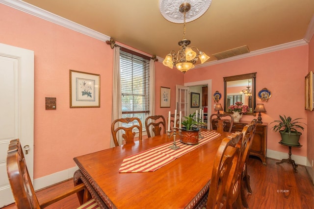 dining room featuring an inviting chandelier, hardwood / wood-style floors, and crown molding