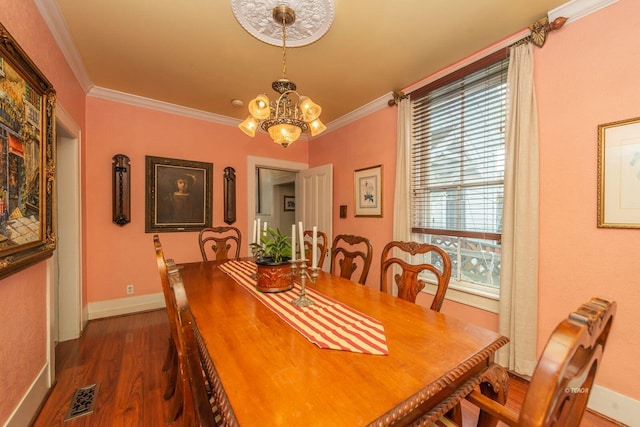 dining area featuring ornamental molding, dark hardwood / wood-style floors, and a chandelier